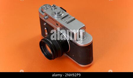 RESEN, MAZEDONIEN. 20. FEBRUAR 2023-Vintage-Objektiv auf orangefarbenem Hintergrund. Zorki-4K ist eine 1970er-Kamera aus der Sowjetära mit 35mm-mm-Entfernungsmesser. Stockfoto