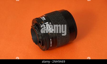 RESEN, MAZEDONIEN. 20. FEBRUAR, 2023-Vintage-Objektiv auf orangefarbenem Hintergrund. Nikkor Zoom af 35-80 F4-5,6d Stockfoto
