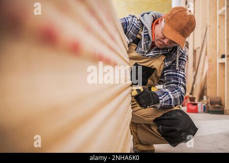 Weißer Bauarbeiter in seinen 40s Zählwerken von Trockenbauplatten Stockfoto
