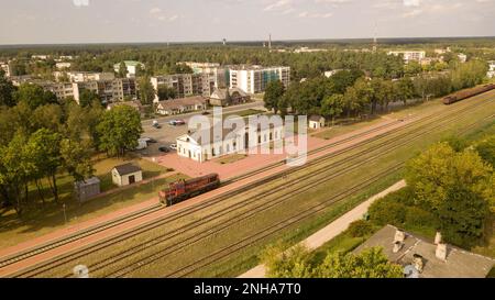 Drohnenfotografie von Zuglokomotiven, die während des Sommertages am Bahnhof warten Stockfoto
