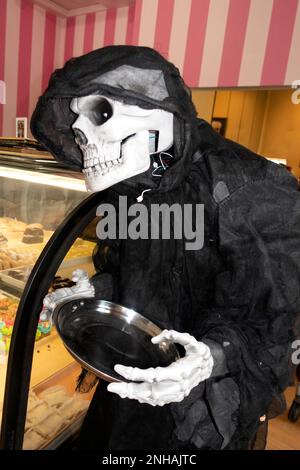 Grim Reaper Skelettfrau in schwarz gekleidet auf einer Ghouls-Halloween-Party in der Mel-O-Glaze Bäckerei. Minneapolis Minnesota MN USA Stockfoto