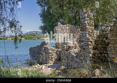 Zerstörte Mauern der antiken römischen Stadt am Ufer des Butrint-Sees / Liqeni i Butrintit, Salzlagune südlich von Saranda, Kreis Vlorë, Südalbanien Stockfoto