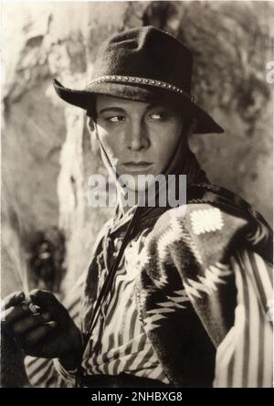 1924 , Vereinigte Staaten : der Stummfilmdarsteller RUDOLPH VALENTINO ( geboren am Rodolfo Guglielmi , 1895 - 1926 ) , die Schülerstill für Einen HEILIGEN TEUFEL ( Notte Nuziale - Hacienda Rouge ) von Joseph Henabery , aus dem Roman von Rex Beach ( 1913 ) - CINEMA MUTO - attore cinematografico - LATIN LOVER - RODOLFO - italoamericano - italo americano - italo americano - emigrante - italo-american - Portrait - ritratto - scarf - foulard - sguardo magntico - hat - cappello - Sigaretta - Zigarette - celebrità personalità fumano - attori Fumatore - Prominente Persönlichkeiten Persönlichkeiten smo Stockfoto