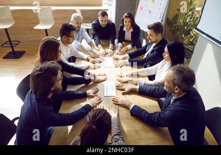 Ein multiethnisches Team von Geschäftsleuten, das ein Arbeitstreffen an einem Bürotisch abhält Stockfoto