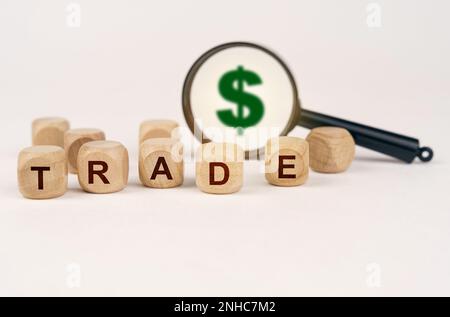 Geschäfts- und Finanzkonzept. In den Finanzberichten gibt es Zahlen von Menschen und Würfeln mit der Inschrift "HANDEL" Stockfoto