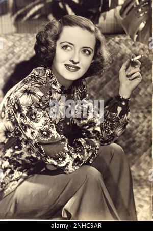 Ca. 1950 : Die amerikanische Filmschauspielerin BETTE DAVIS ( 1908 - 1989 ) - KINO - Porträt - Rituto - Lächeln - sorriso - Sigaretta - Zigarette - personalità celebrità attori che fumano attrice che fuma - Fumatore - Prominente Persönlichkeiten Raucher ---- Archivio GBB Stockfoto