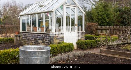 Gewächshaus und ein inaktiver Küchengarten während eines britischen Winters, Pflanzmaschinen, Pflanztöpfe Stockfoto