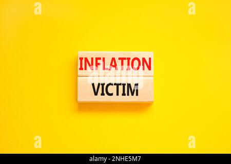 Symbol für Inflationsopfer. Konzeptwörter Inflationsopfer auf Holzblock. Wunderschöner gelber Hintergrund für den Tisch. Das Konzept der Inflationsopfer von Unternehmen. Stockfoto