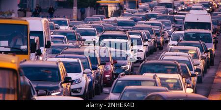 Die Ruhe der Morgenluft wird durch die Geräusche von hupenden Hörnern und quietschenden Bremsen gestört, die auf diesem Foto der morgendlichen Hauptverkehrszeit festgehalten werden Stockfoto