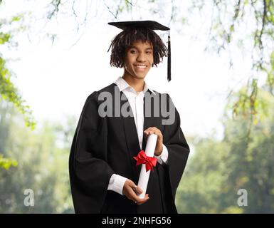 Männlicher afroamerikanischer Graduierter mit einem Diplom im Freien Stockfoto