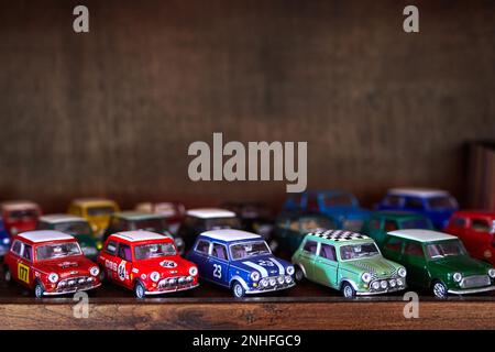 Miniatur-Mini-Cooper-Autos auf einem Holzregal Stockfoto