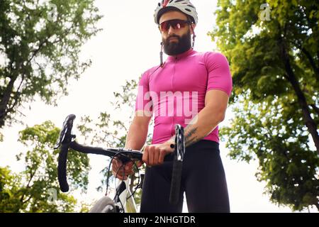 Attraktiver junger Mann fährt Fahrrad Stockfoto