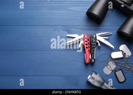 Flache Verlegung mit kompaktem tragbarem Multitool und Zubehör auf blauem Holztisch. Platz für Text Stockfoto