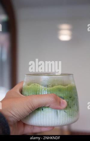 Handgehaltener Eistee mit Matcha-Grün, Stockfoto Stockfoto