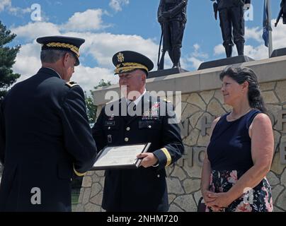 General Darrell J. Guthrie, ehemaliger kommandierender General, 88. Readiness Division, erhält eine von Präsident Joseph R. Biden vom pensionierten Major Mark McQueen unterzeichnete Danksagungsurkunde, die Guthries Frau Shari anlässlich Guthries Ruhestandszeremonie im Veterans Memorial Park, Fort McCoy, Wisconsin, am 30. Juli ansieht. 2022. Stockfoto