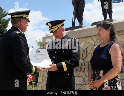 Army Reserve Major General Darrell J. Guthrie, ehemaliger kommandierender General, 88. Readiness Division, lächelt, als er sein Ruhestandszertifikat vom pensionierten Major Mark McQueen erhält, als Guthries Frau Shari, während Guthries Ruhestandszeremonie im Veterans Memorial Park, Fort McCoy, Wisconsin, Juli 30 lächelt. 2022. Stockfoto