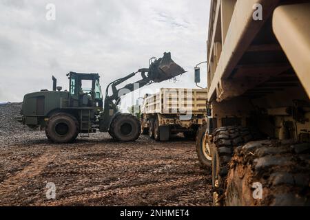 Soldaten der 130. Ingenieurbrigade, 84. Ingenieurbattalion füllen Kies mit einem Lader in M1157 Kippladern während der gemeinsamen Straßenreparatur einer Feldübungsstrecke auf der Python 1 Range in Baturaja, Indonesien, am 30. Juli 2022 als Teil von Garuda Shield 2022. Operation Pathways und eine langjährige, jährliche, bilaterale Militärübung zwischen dem US-Militär, der indonesischen Nationalarmee, verstärken die Verpflichtungen der USA gegenüber unseren Verbündeten und anderen regionalen Partnern und stärken die gemeinsame Bereitschaft und die Interoperabilität, gemeinsam zu kämpfen und zu gewinnen. Stockfoto