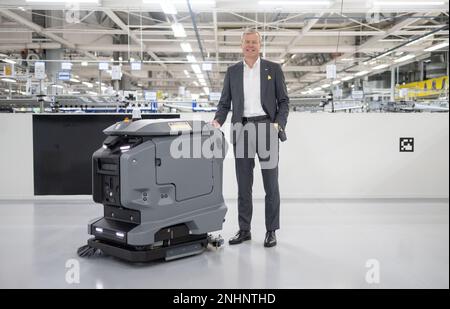 Winnenden, Deutschland. 20. Februar 2023. Hartmut Jenner, Vorstandsvorsitzender von Alfred Kärcher SE & Co KG, steht neben einem vollständig autonomen Wäschetrockner Kira B 50. Kredit: Marijan Murat/dpa/Alamy Live News Stockfoto