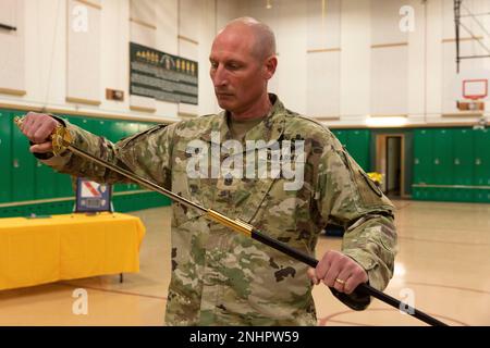 Alaska Army National Guard Command Sgt. Major Ryan Weimer enthüllt das Schwert während einer Zeremonie zum Verantwortungswechsel im Alcantra Armory in Wasilla, Alaska, 1. August 2022. Oberstleutnant Julie Small gab die Verantwortung als Oberbefehlshaber der 297. Regionalen Unterstützungsgruppe für Weimer auf. (Alaska National Guard Foto von Victoria Granado) Stockfoto