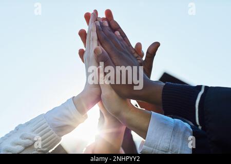 Wir haben es bis ganz nach oben geschafft. Nahaufnahme einer Gruppe von unbekannten Schülern High Fiving am Abschlusstag. Stockfoto