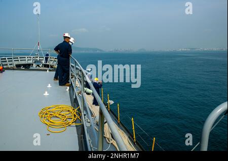 VISAKHAPATNAM, Indien (1. August 2022) - Seeleute und Sealift-Militärkommando, die dem Emory S. Unterseebooter USS Frank Cable (AS 40) zugewiesen wurden, beobachten die Ankunft des Schiffs in Visakhapatnam, Indien, 1. August 2022. Frank Cable ist derzeit auf Patrouille und führt expeditionäre Wartungs- und Logistikarbeiten im 7.-Flottenbereich der USA durch, um ein freies und offenes Indo-Pacific zu unterstützen. Stockfoto