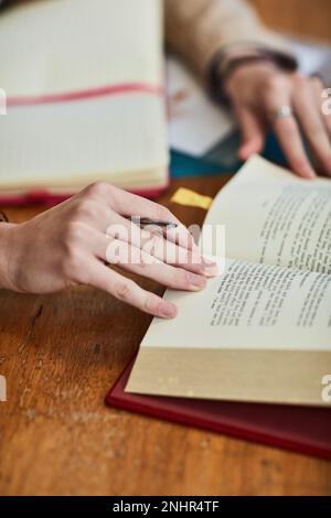 Ich durchblättere Notizen für ihre nächste Klasse. Nahaufnahme eines unidentifizierbaren Studenten, der auf dem Campus arbeitet. Stockfoto