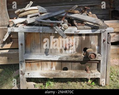 Kiste mit alten landwirtschaftlichen Holzwerkzeugen im Hinterhof eines Dorfhauses Stockfoto