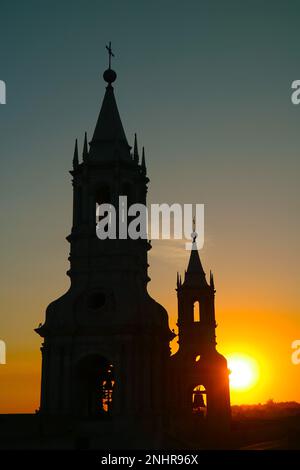 Silhouette des Glockenturms der Basilika-Kathedrale von Arequipa mit atemberaubendem hellen Sonnenuntergang, Arequipa, Peru, Südamerika Stockfoto