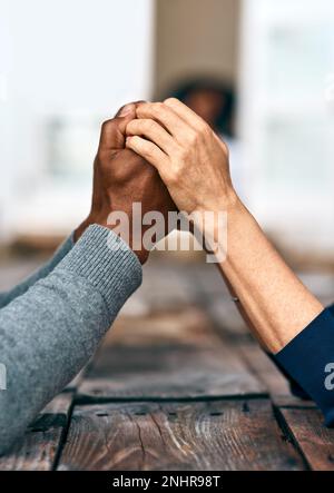 Dann schaffen wir es zusammen. Zwei nicht wiedererkennbare Menschen, die Händchen halten. Stockfoto