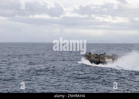 Ein Landungsschiff der US Navy, Luftkissen mit Naval Beach Unit 7, fliegt an Land während des Brunnendeckens an Bord der USS New Orleans (LPD 18) in der Philippinischen See, 1. August 2022. Landungsboote und Luftkissen werden für den Transport von Fahrzeugen und Personal vom Schiff an Land verwendet. Die 31. MEU operiert an Bord der Schiffe der Tripolier Expeditionsstreikgruppe im siebten Einsatzgebiet der Flotte, um die Interoperabilität mit Verbündeten und Partnern zu verbessern und als einsatzbereite Eingreiftruppe zur Verteidigung von Frieden und Stabilität in der indopazifischen Region zu dienen. 31. MEU, HIMARS, LCAC, LPD 18, NBU 7, USS New Orleans, Stockfoto