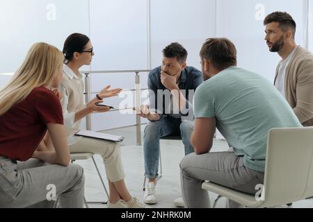 Psychotherapeut, der mit einer Gruppe drogenabhängiger Menschen bei Therapiesitzungen im Haus zusammenarbeitet Stockfoto