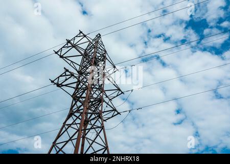 Telefonmast und Kabel gegen blauen Himmel mit Wolken Stockfoto