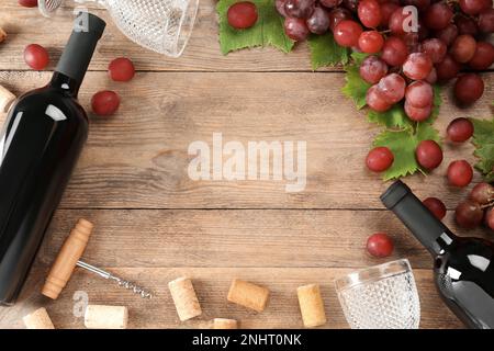 Flache Laienzusammensetzung mit leckerem Rotwein und Trauben auf Holztisch, Platz für Text Stockfoto