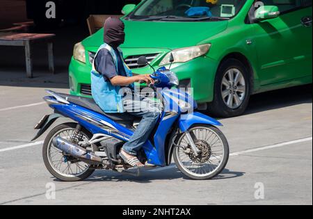 Der Taxifahrer in einer blauen Weste fuhr auf der Straße nach Thailand Stockfoto