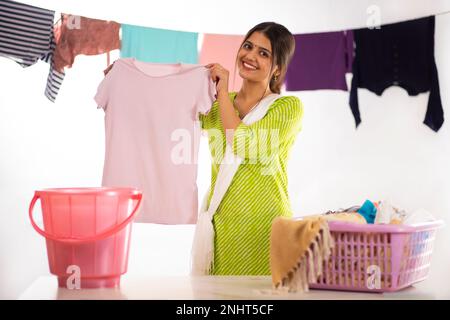 Fröhliche junge Frau, die nach dem Händewaschen Stoff zeigt Stockfoto