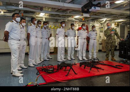 VISAKHAPATNAM, Indien (02. August 2022) – USA Navy Fähnrich Sean Smith, ein Waffenhandhaber an Bord des Emory S. Land-Class-U-Boot-Tenderschiffs USS Frank Cable (AS 40), erläutert den indischen Navy-Seeleuten die Waffenkapazitäten des Schiffs während einer Rundfahrt durch das Schiff, während sie in Visakhapatnam, Indien, am 2. August 2022 festsaßen. Frank Cable ist derzeit auf Patrouille und führt expeditionäre Wartungs- und Logistikaufgaben im 7. Flottenbereich durch, um einen freien und offenen Indo-Pacific zu unterstützen. Stockfoto