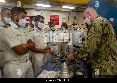 VISAKHAPATNAM, Indien (2. August 2022) – USA Navy Commander. Brian Banazwski, ein Reparaturbeamter an Bord des Unterseeboots USS Frank Cable (AS 40) der Emory S. Land-Klasse, erläutert den Seeleuten der indischen Marine die Reparaturkapazitäten des Schiffes während einer Schiffsbesichtigung, während sie in Visakhapatnam, Indien, am 2. August 2022 festsaßen. Frank Cable ist derzeit auf Patrouille und führt expeditionäre Wartungs- und Logistikaufgaben im 7. Flottenbereich durch, um einen freien und offenen Indo-Pacific zu unterstützen. Stockfoto