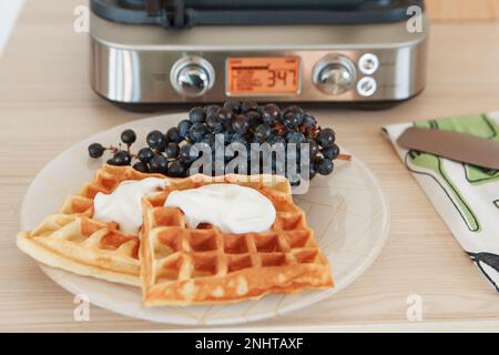 Wiener Waffeln mit Feigen und schwarzen Trauben zu Hause und im Restaurant. Gesundes, gesundes Frühstück für Vegetarier. Hochwertiges Foto Stockfoto