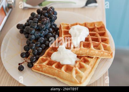 Wiener Waffeln mit Feigen und schwarzen Trauben zu Hause und im Restaurant. Gesundes, gesundes Frühstück für Vegetarier. Hochwertiges Foto Stockfoto