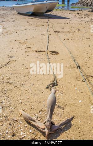 Anker vom Fischerboot im Sand bei Ebbe. Cabanas de Tavira, Portugal Stockfoto