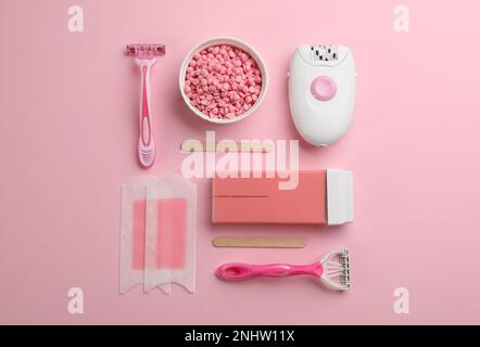 Set mit Epilierwerkzeugen und Produkten auf pinkfarbenem Hintergrund, flach liegend Stockfoto