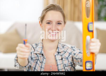 Hübsche junge Frau mit Niedrigkeit und Schraubenzieher Stockfoto