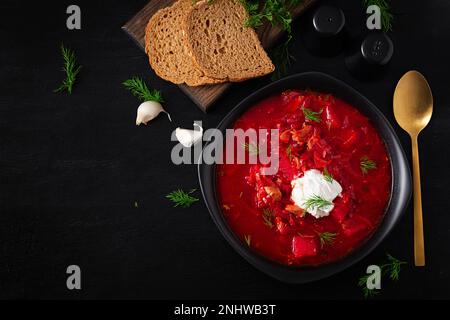 Traditioneller ukrainischer Borschtsch. Schüssel Rote-Bete-Suppe Borsch mit weißer Sahne. Süße Rote-Beete-Suppe. Ukrainisches Essen. Draufsicht, über Kopf Stockfoto