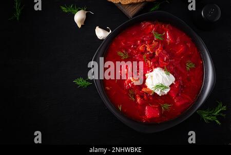Traditioneller ukrainischer Borschtsch. Schüssel Rote-Bete-Suppe Borsch mit weißer Sahne. Süße Rote-Beete-Suppe. Ukrainisches Essen. Draufsicht, über Kopf Stockfoto