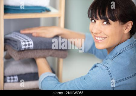 Glückliche Frau, die im Hotelzimmer Handtücher wechselte Stockfoto