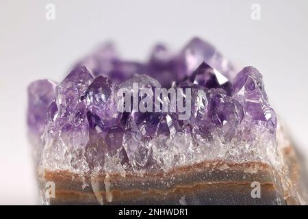 Amethyst ist eine fliederfarbene Quarzsorte. Hier sind Kristalle, die von einem geschliffenen Geode freigelegt wurden. Stockfoto