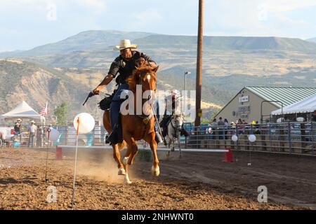 Staff Sgt. Justin Robinson, ein Motortransportunternehmen im Sondereinsatz mit dem 4. Infanterie Division Fort Carson Mounted Color Guard, schießt auf seinem Pferd, Sgt. 1. Class Link, für die Garfield County Fair, Rifle, Colorado, am 3. August 2022 auf seinen Zielballon. Die Garfield County Fair ist ein alljährliches Grundstück, um die Tradition des Westens zu bewahren. Stockfoto