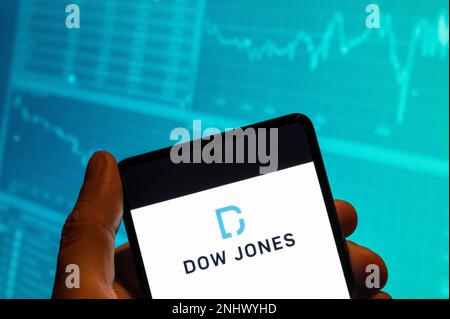 China. 19. Februar 2023. In dieser Fotoabbildung wird der amerikanische Börsenindex des 30 prominenten Unternehmen-Logos „Dow Jones Industrial Average“ (DJIA) auf einem Smartphone mit einem Diagramm des Börsenindex im Hintergrund angezeigt. (Foto: Budrul Chukrut/SOPA Images/Sipa USA) Guthaben: SIPA USA/Alamy Live News Stockfoto