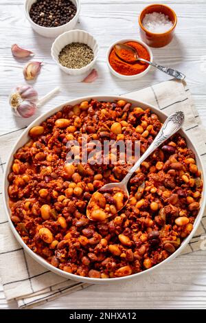 Bohnen und Würstchen mit Kidney Beans, großen Nordbohnen, Schwarzäugigen Erbsen, Pinto Beans, Kichererbsen, Fleisch- und Tomatensoße in Backform auf weißem w Stockfoto