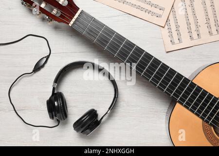 Komposition mit Gitarre- und Musikkommentaren auf hellem Holztisch, flach liegend Stockfoto